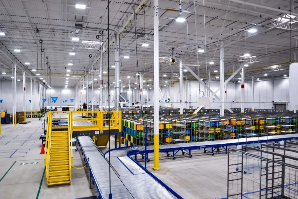 The inside of a large warehouse with yellow and blue lighting.
