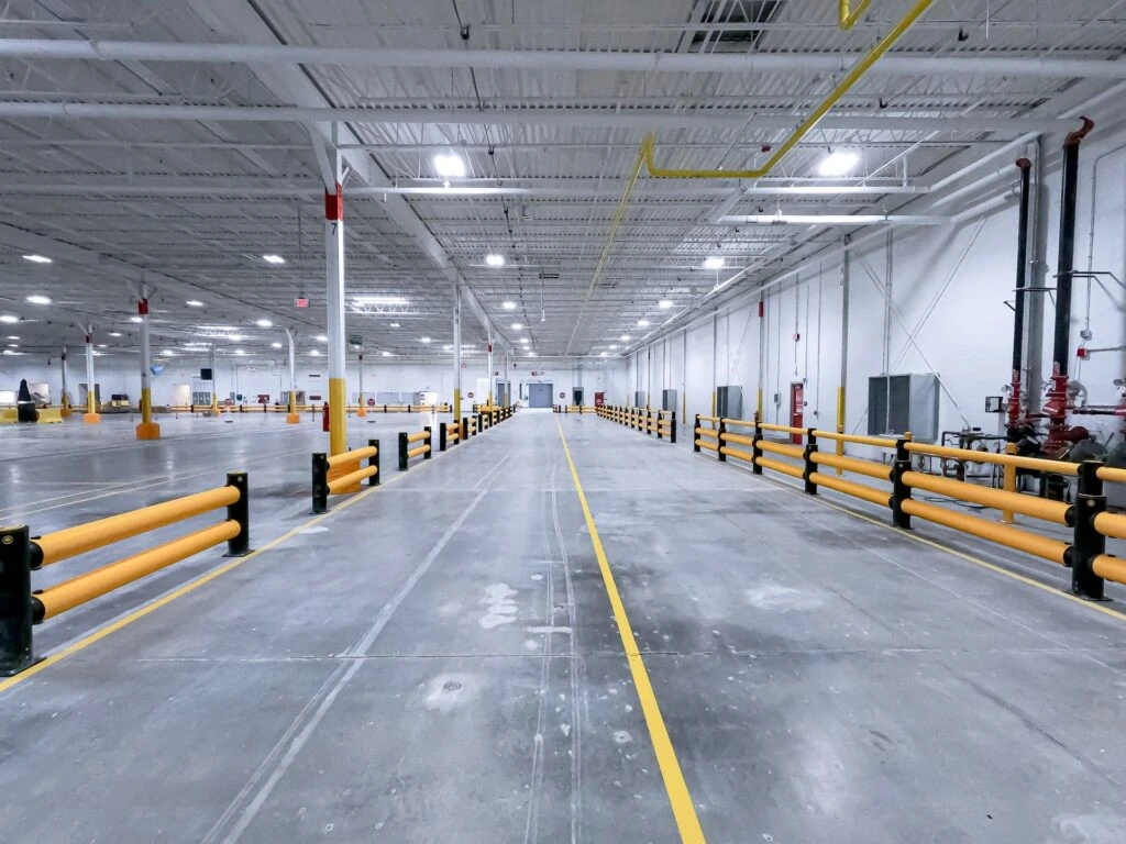 The inside of a warehouse with yellow railings.