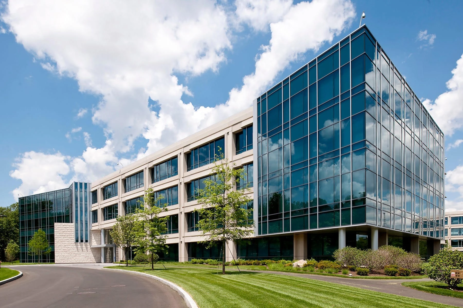 An office building with glass windows and grass.