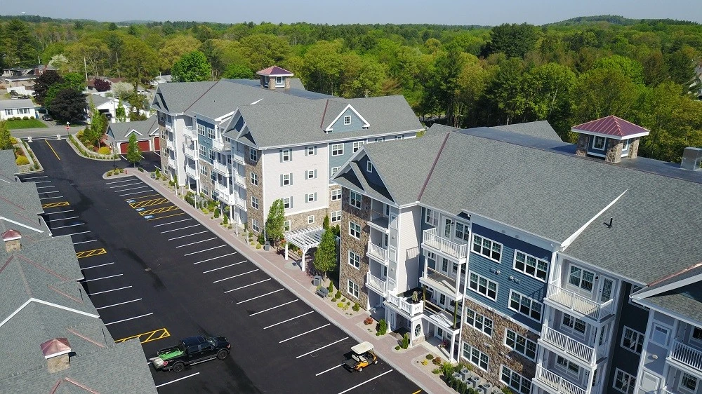 An aerial view of an apartment complex with a parking lot.