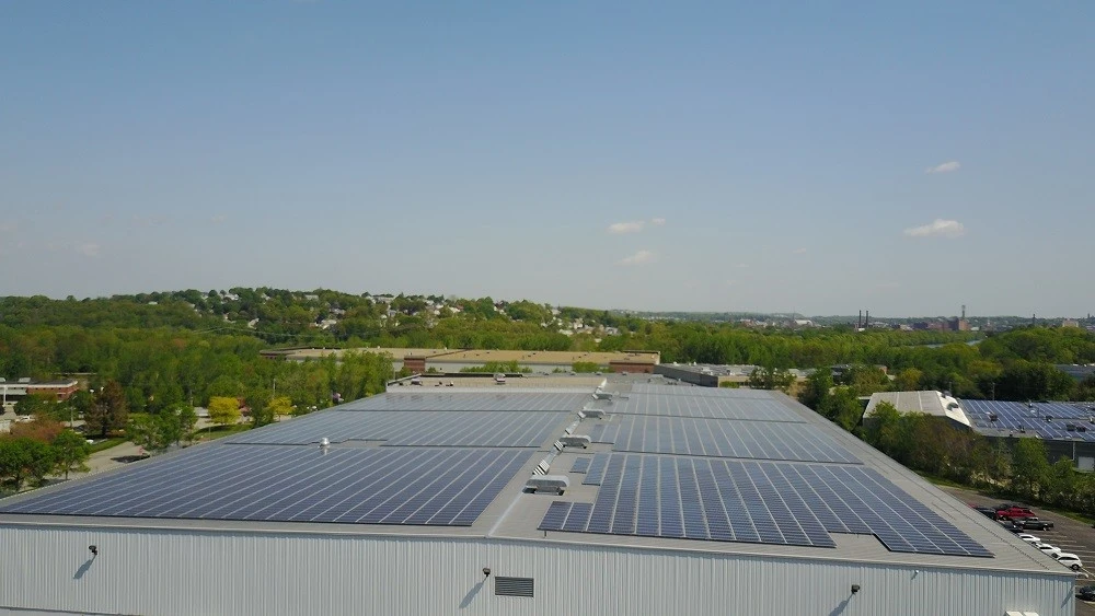 An aerial view of solar panels on the roof of a building.