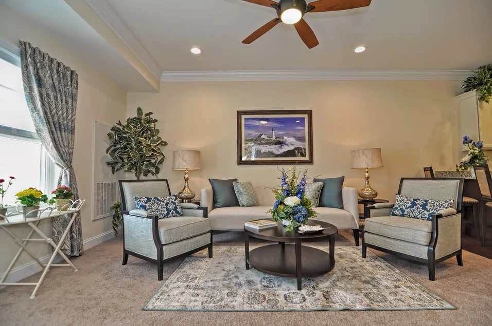 A living room with a ceiling fan and furniture.