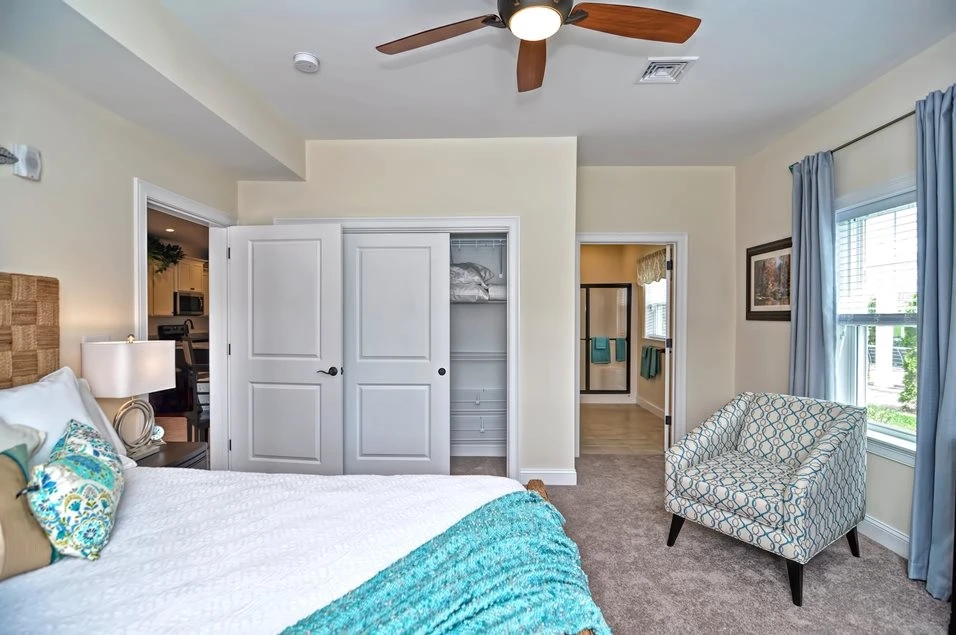 A bedroom with a ceiling fan and a bed.