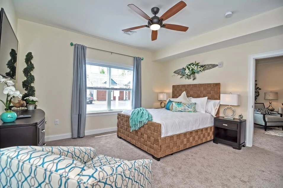 A bedroom with a bed and a ceiling fan.