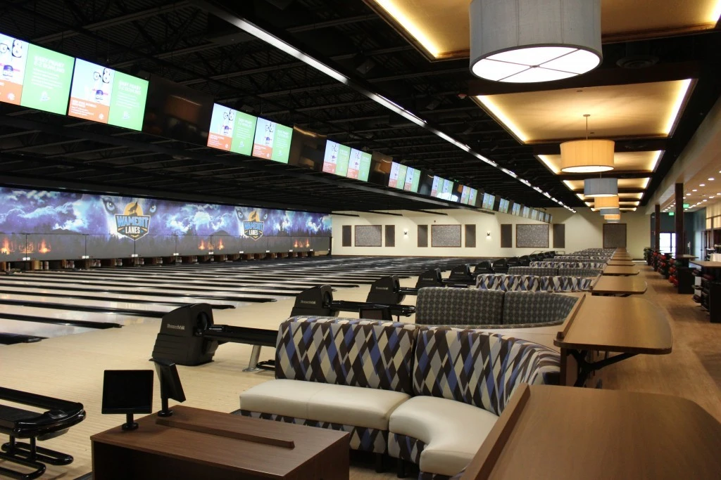 A bowling alley with a large number of bowling lanes.