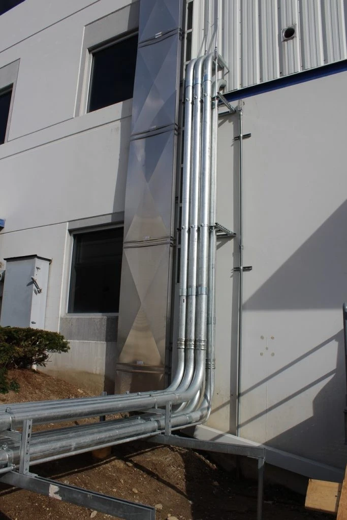 A building with a metal pipe in front of it.