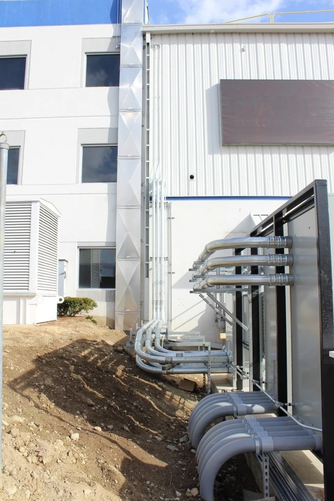 A building with pipes and pipes outside of it.