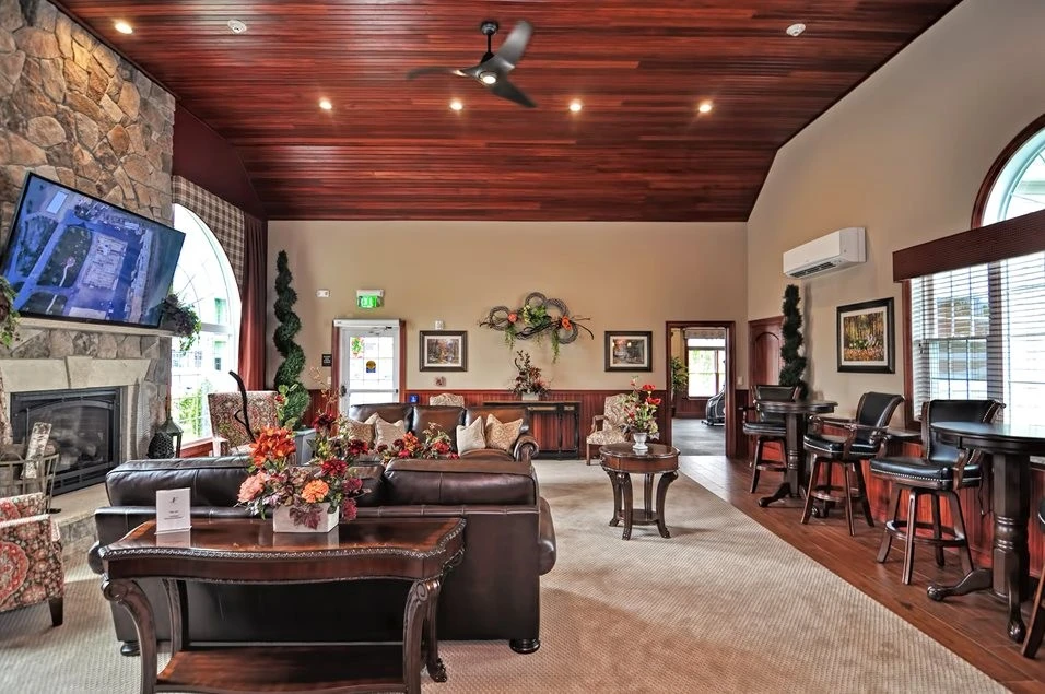 A large living room with a fireplace and a flat screen tv.