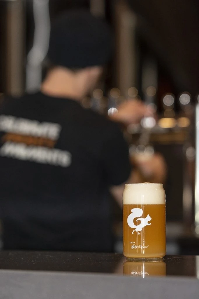 A man is pouring a beer into a glass.