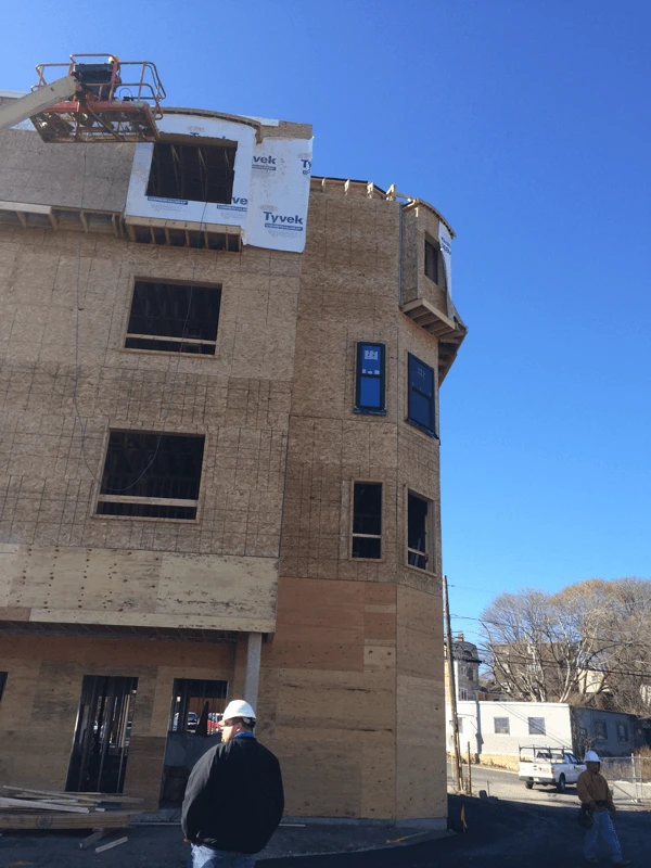 A man is standing in front of a building that is under construction.