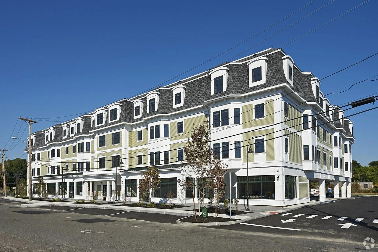 An apartment building on the corner of a street.