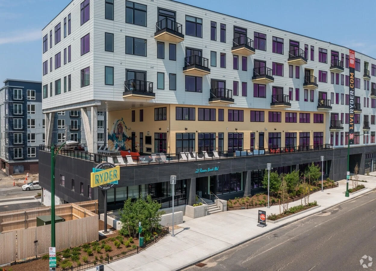 An apartment building with balconies on the side of the street.