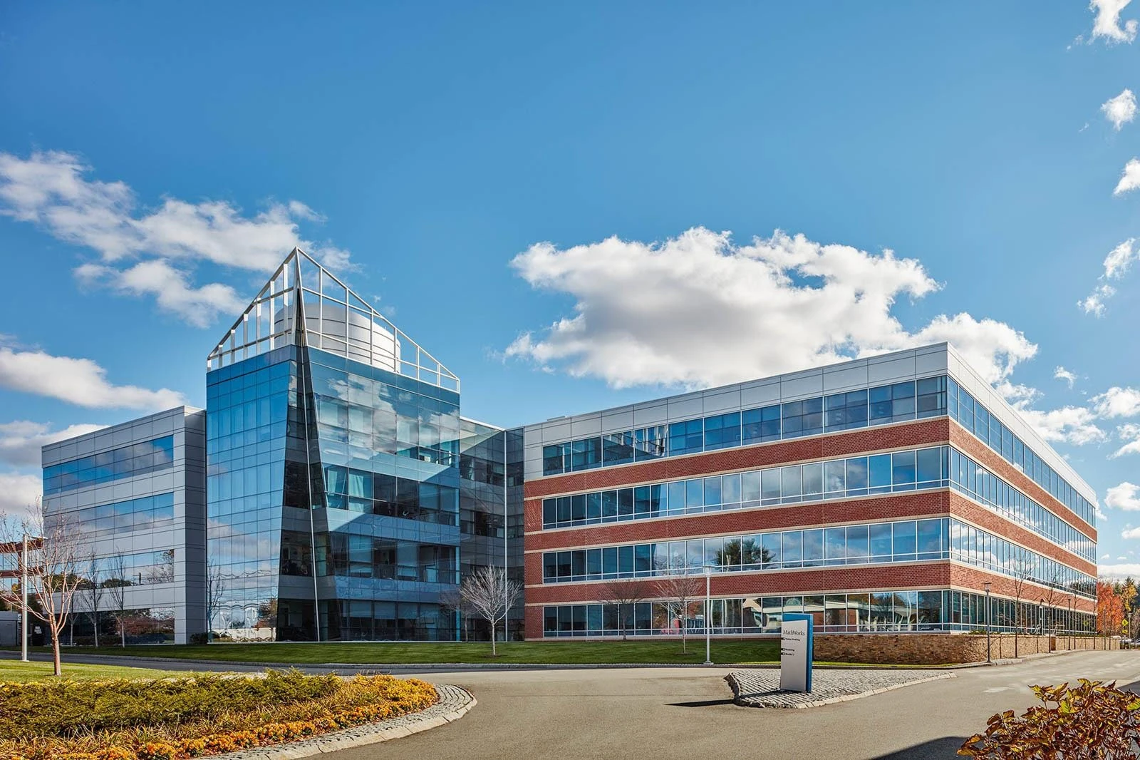 An office building with glass windows and a blue sky.