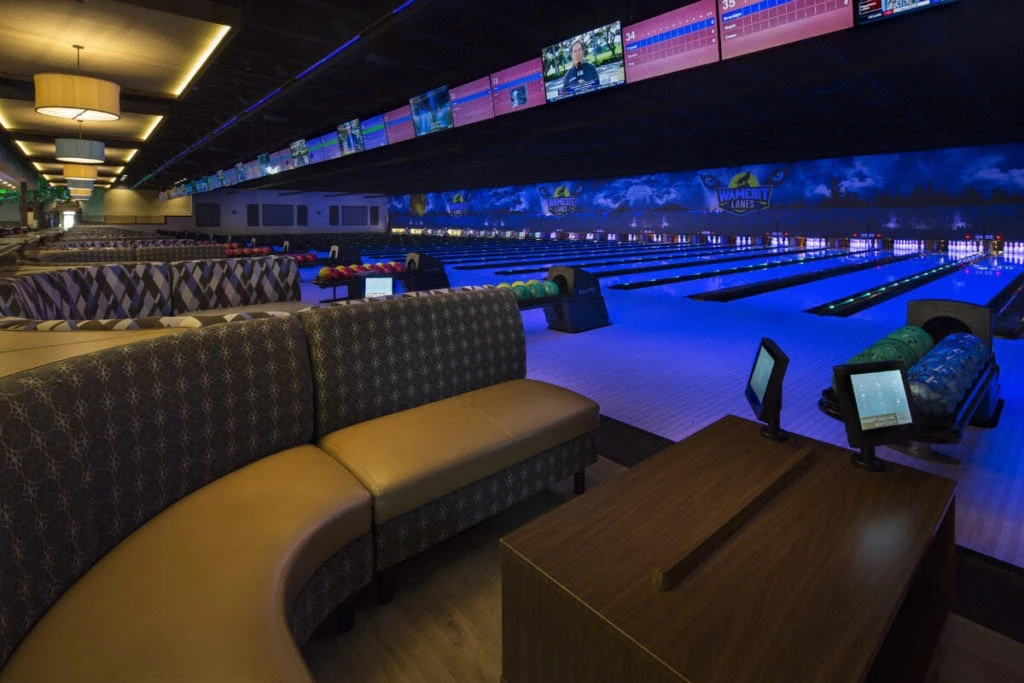 A bowling alley with a large number of bowling lanes.