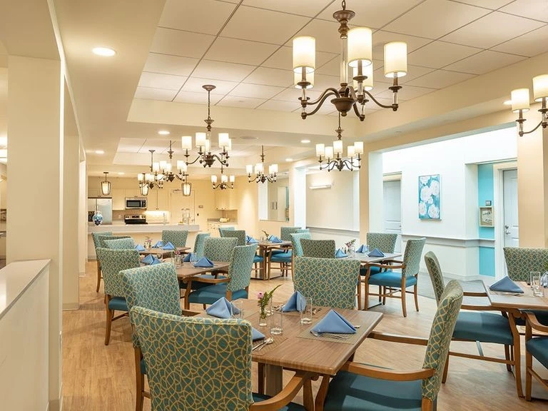 A dining room with blue chairs and a chandelier.