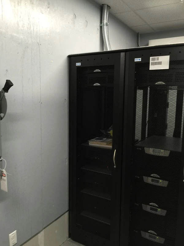 A server room with a black cabinet next to it.
