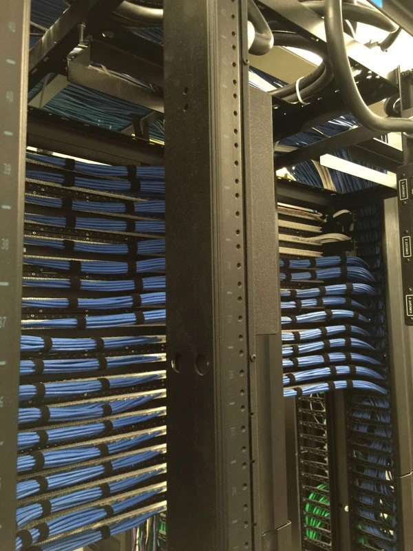 A rack full of blue wires in a data center.