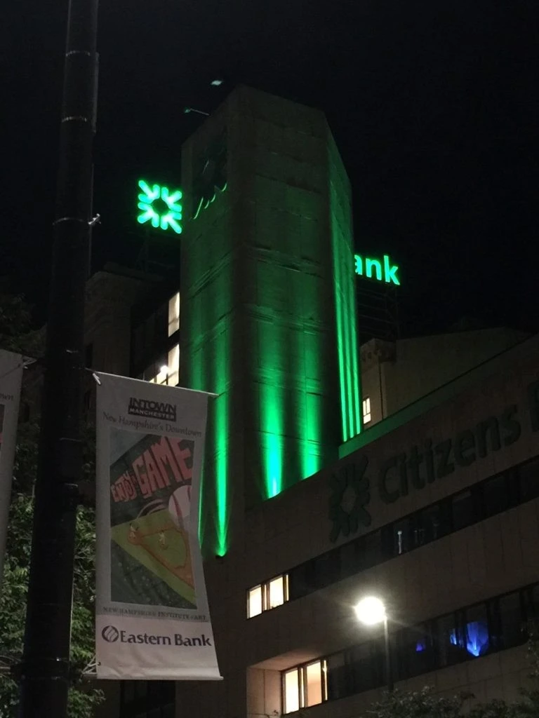 Citizens bank at night with green lights.