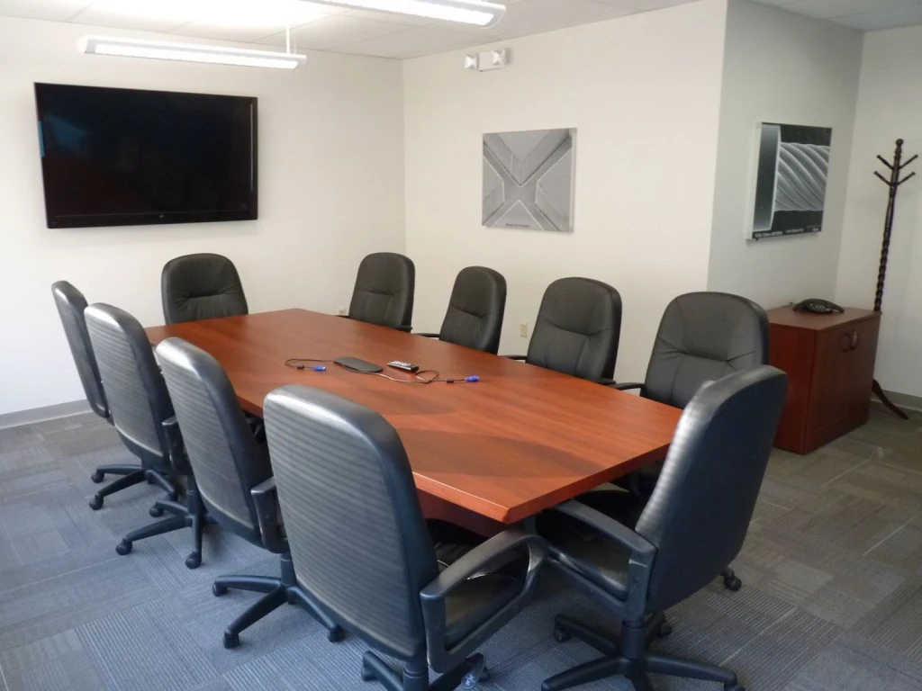 A conference room with a large table and chairs.