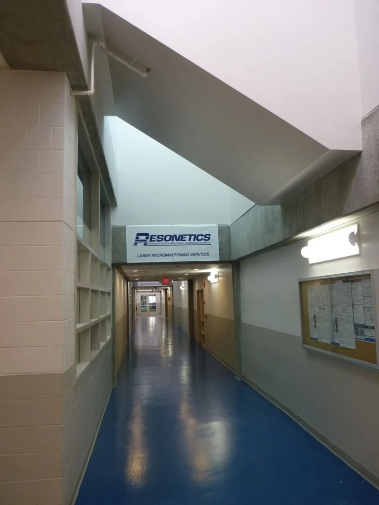 A hallway with a blue floor and a sign on it.