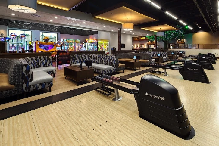 A bowling alley with a large number of bowling lanes.