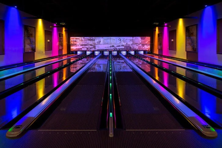 A bowling alley with colorful lights.