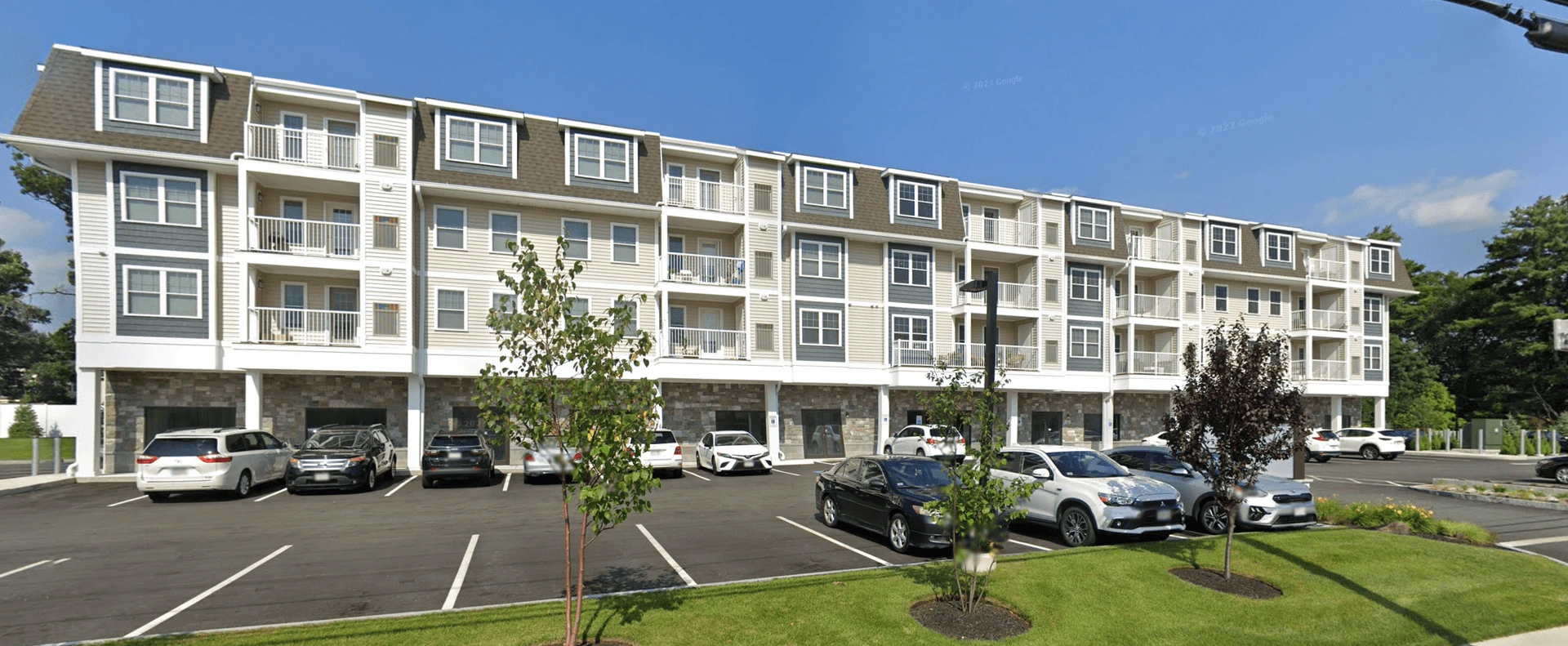 A large apartment building with cars parked in front of it.