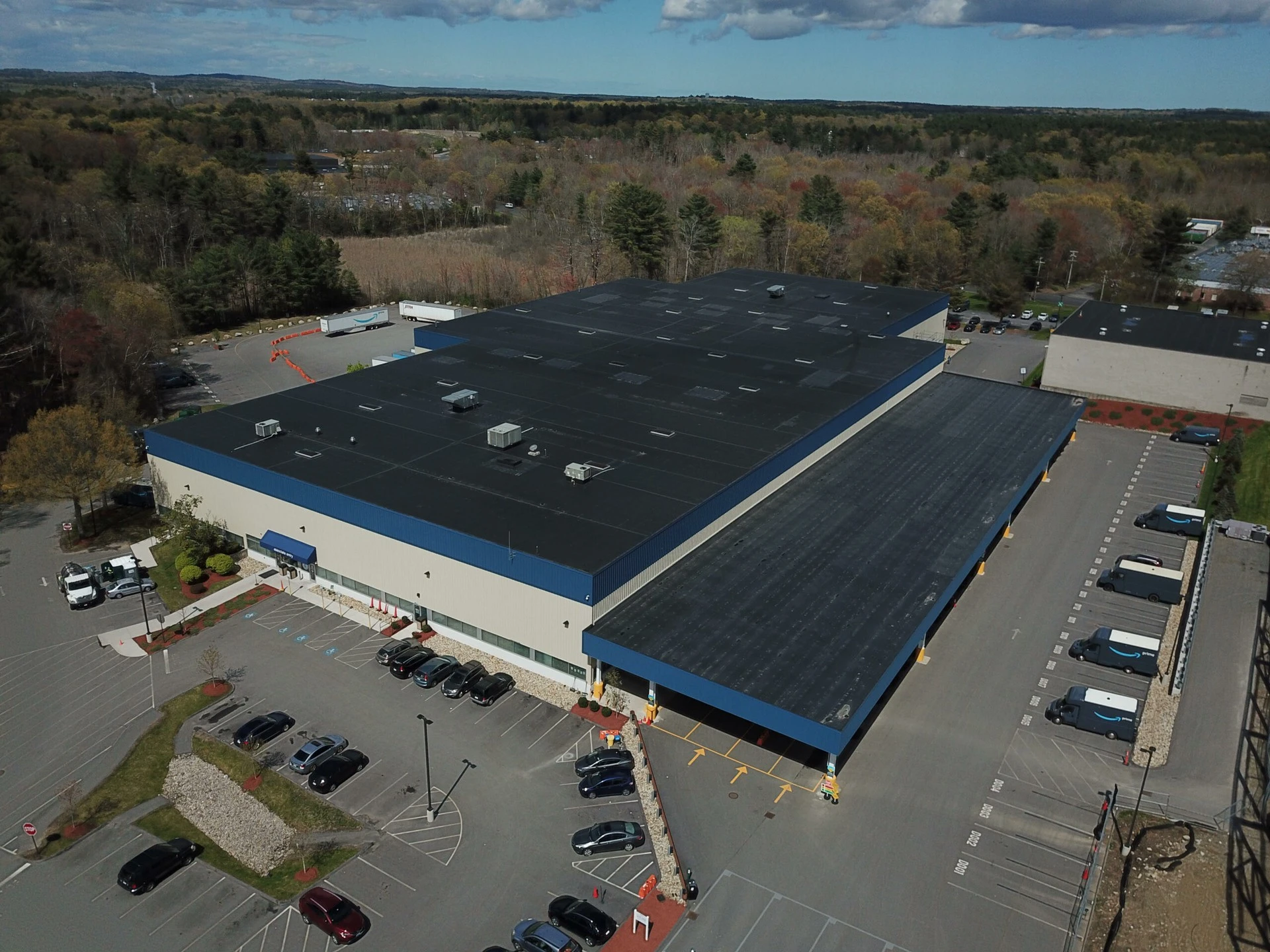 An aerial view of a parking lot with a blue roof.