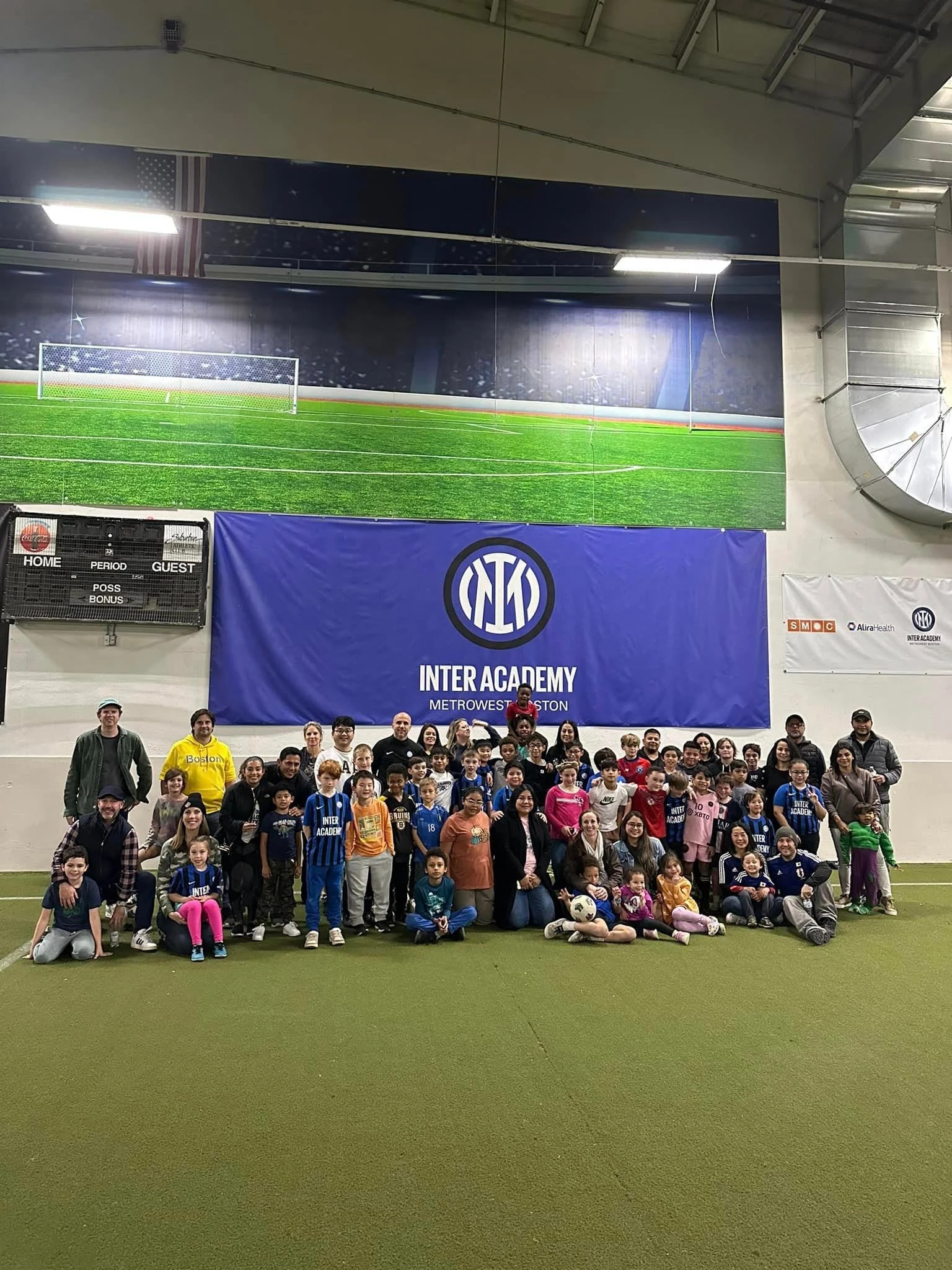 A group of children posing for a photo in an indoor field.