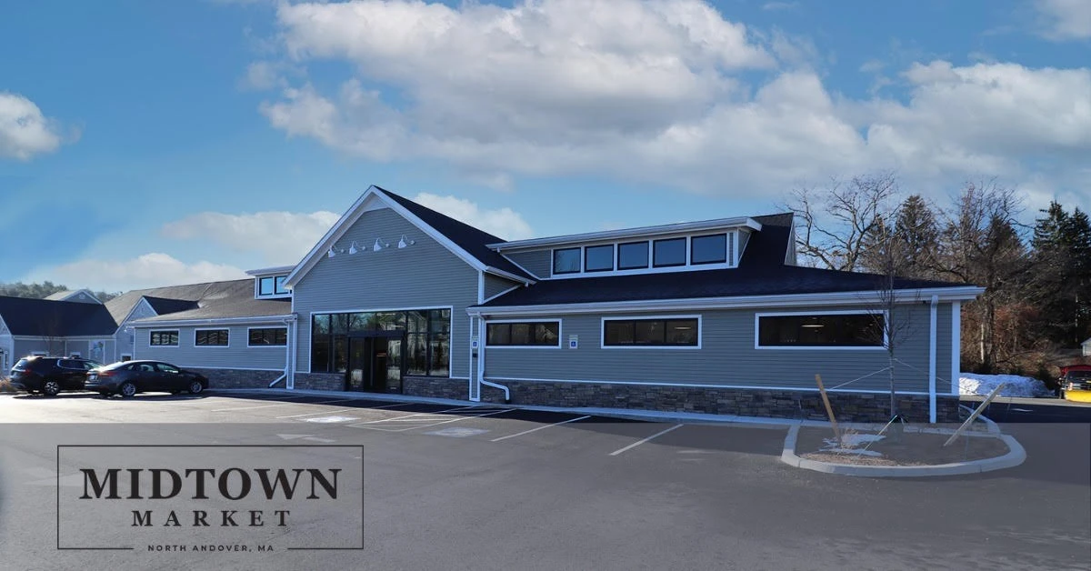 The midtown market building is in the middle of a parking lot.
