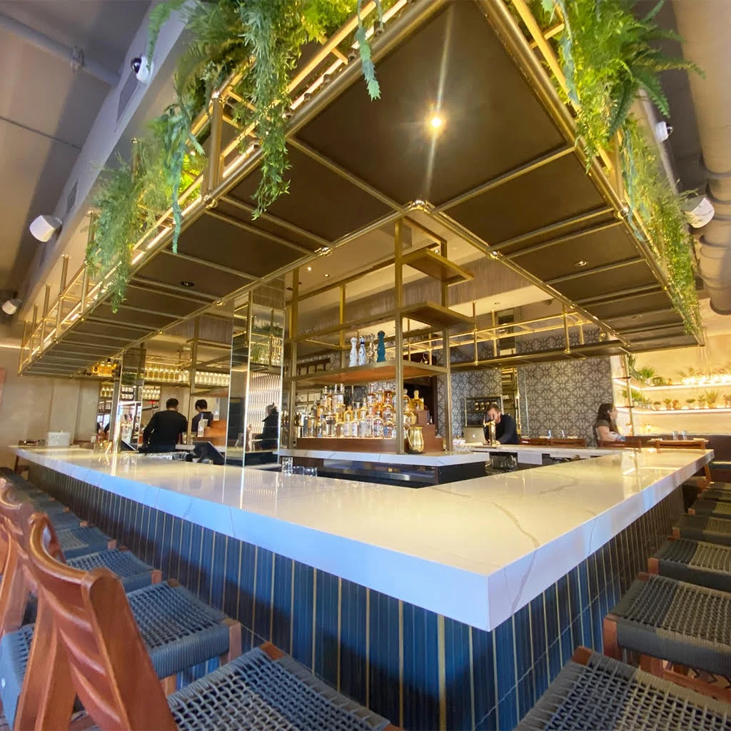 The interior of a restaurant with a bar and chairs.