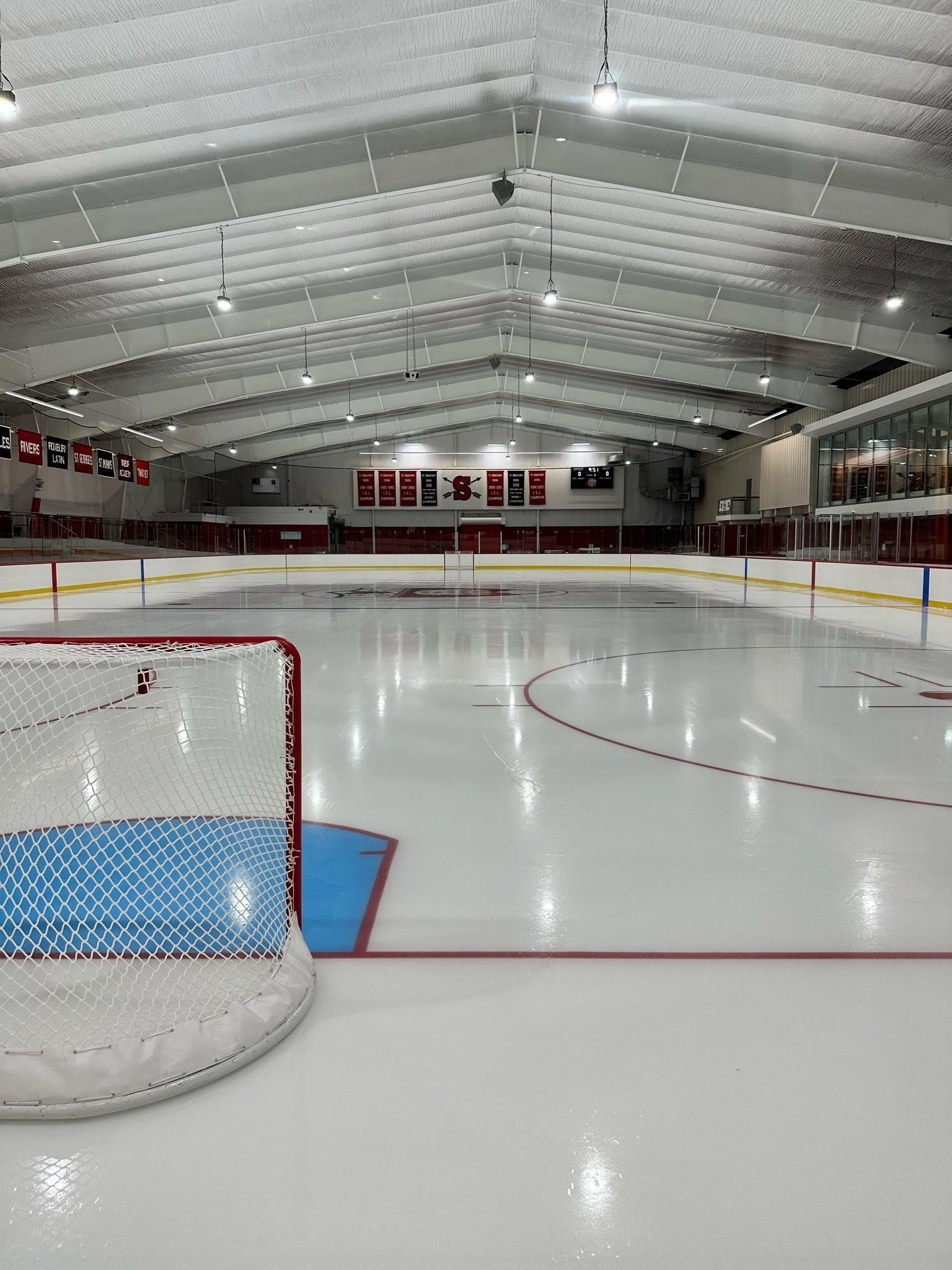 An indoor ice rink with a goal in the middle.