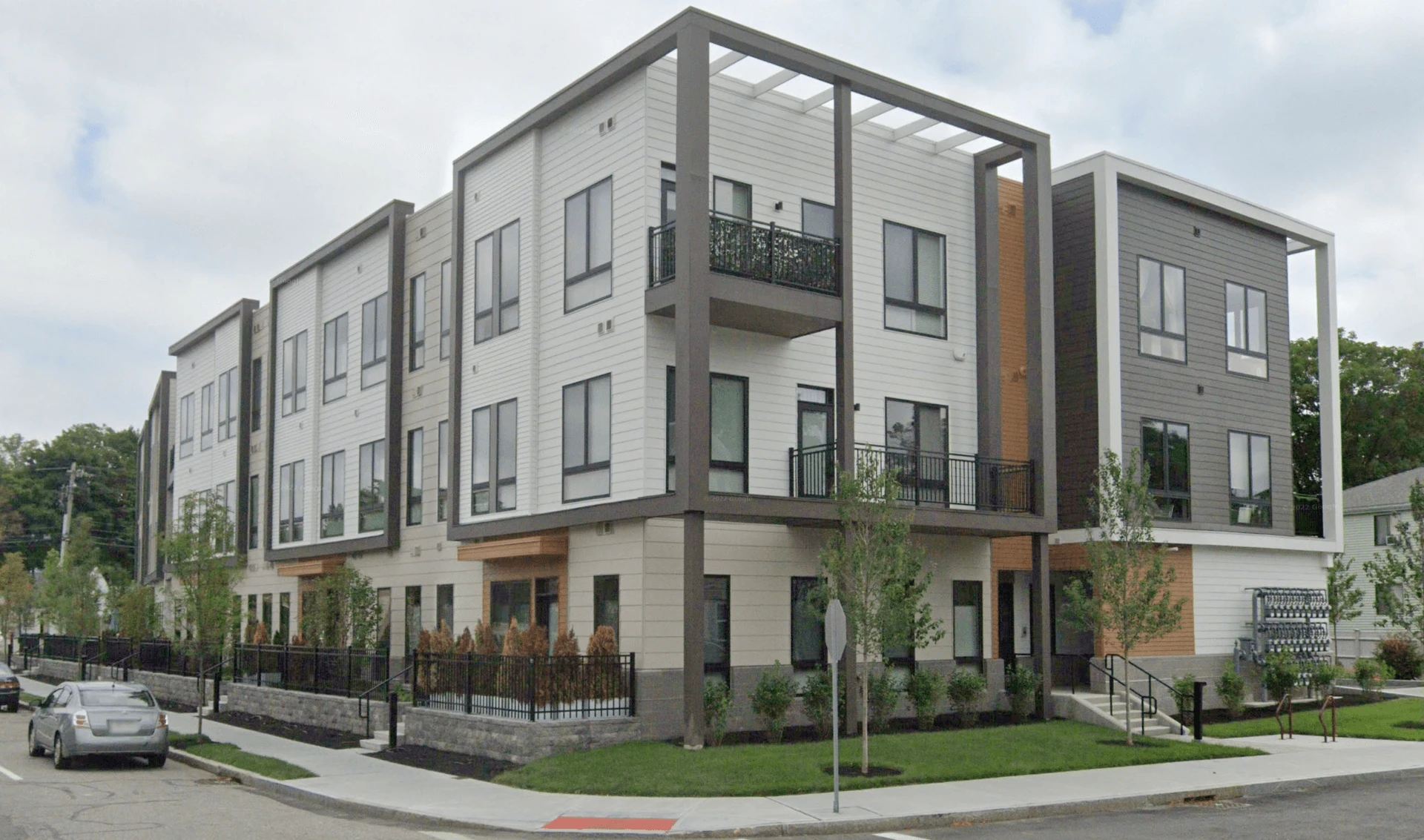 An apartment building with a car parked in front of it.