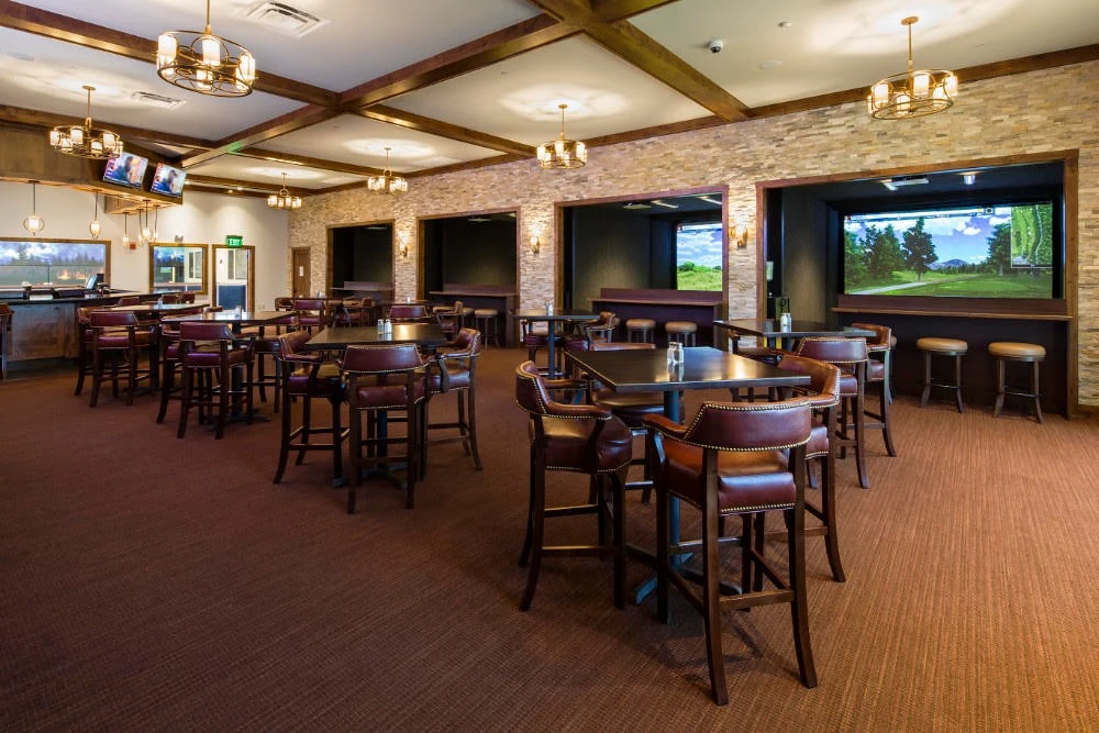 A bar with stools and a tv.
