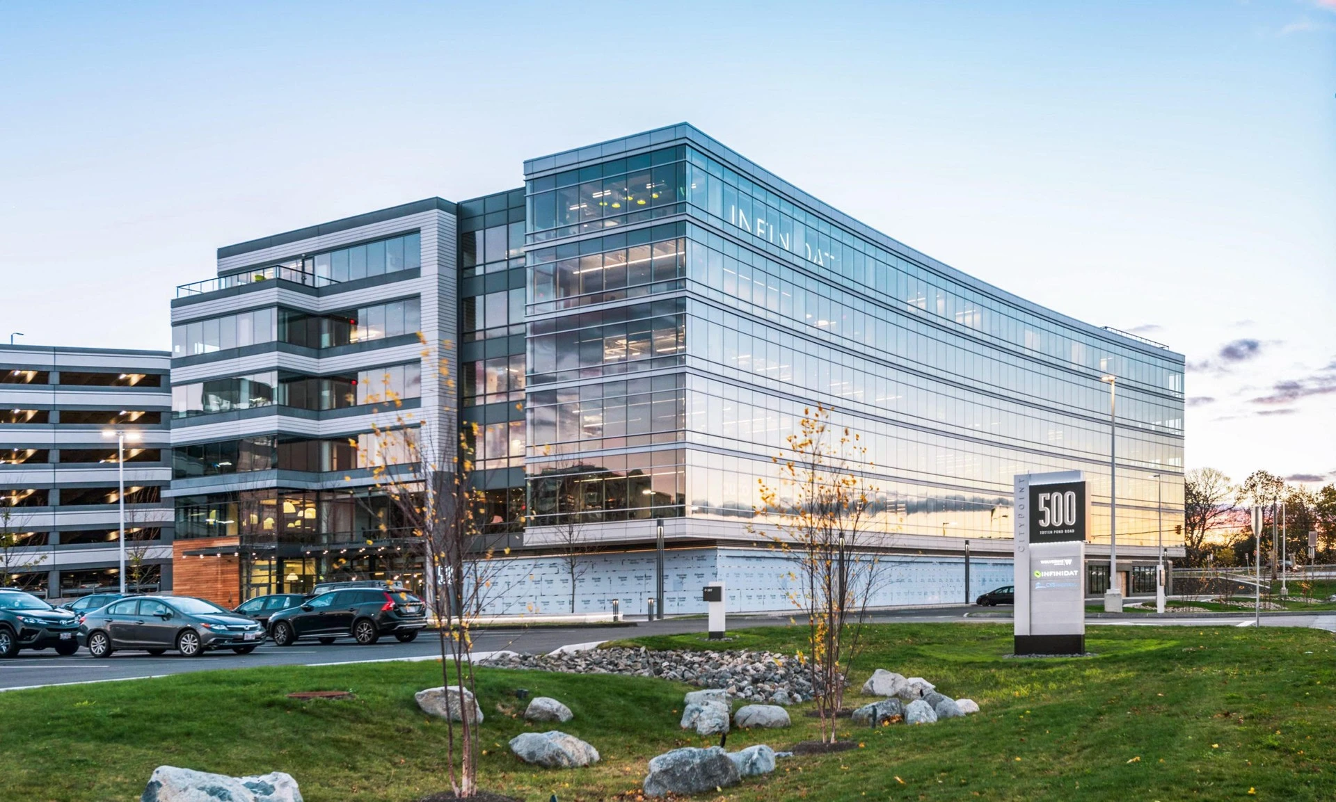 A modern office building with a parking lot in the background.