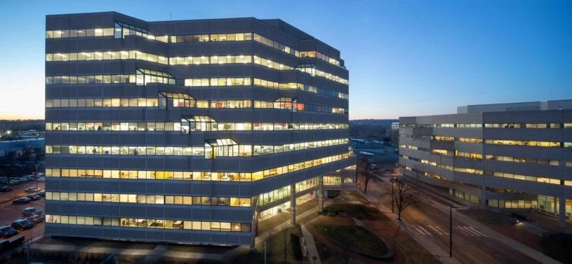 A modern office building at dusk in a city.