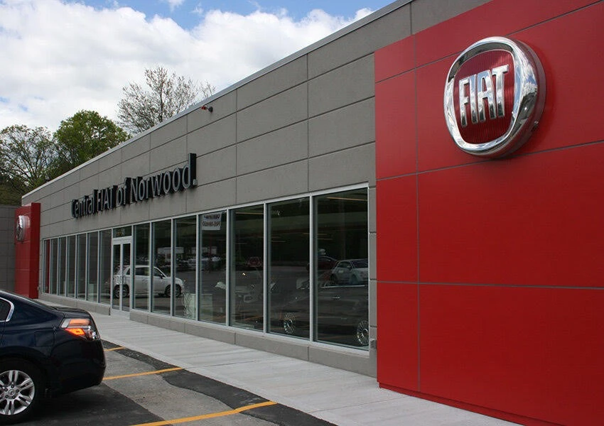 A car is parked outside of a car dealership.