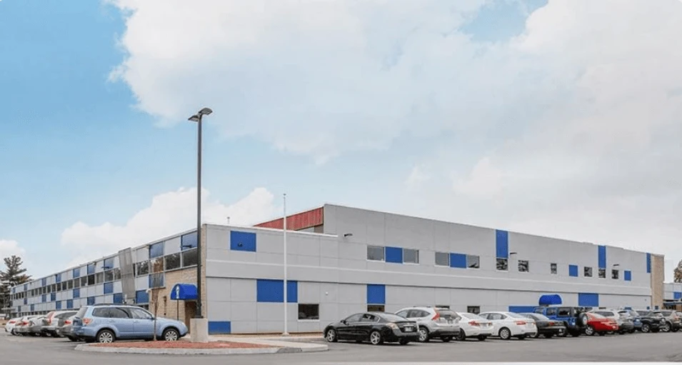 A blue and white building with cars parked in front of it.
