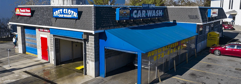 A garage with a blue awning and parked cars.