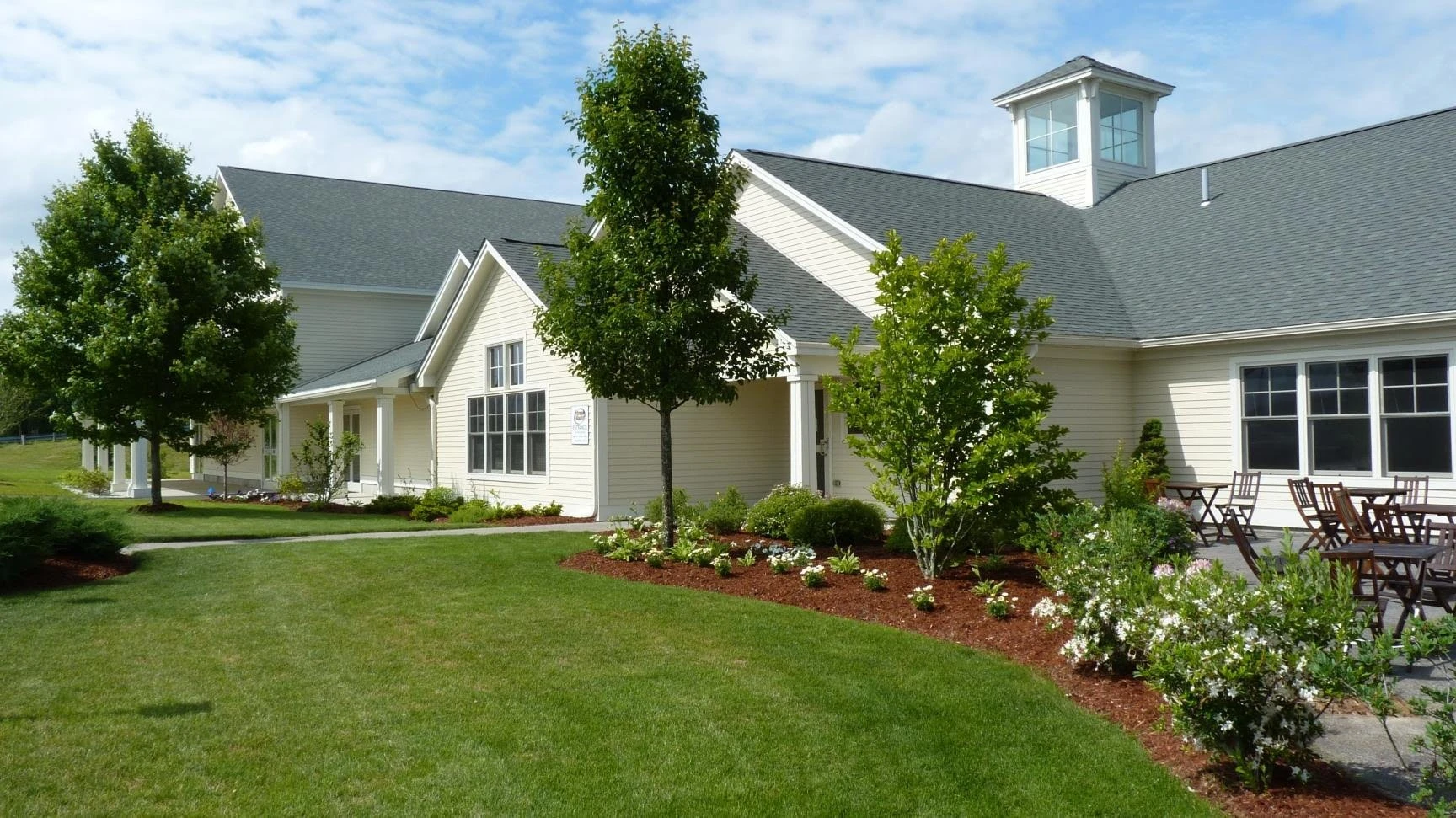 A house with a lawn and trees in front of it.