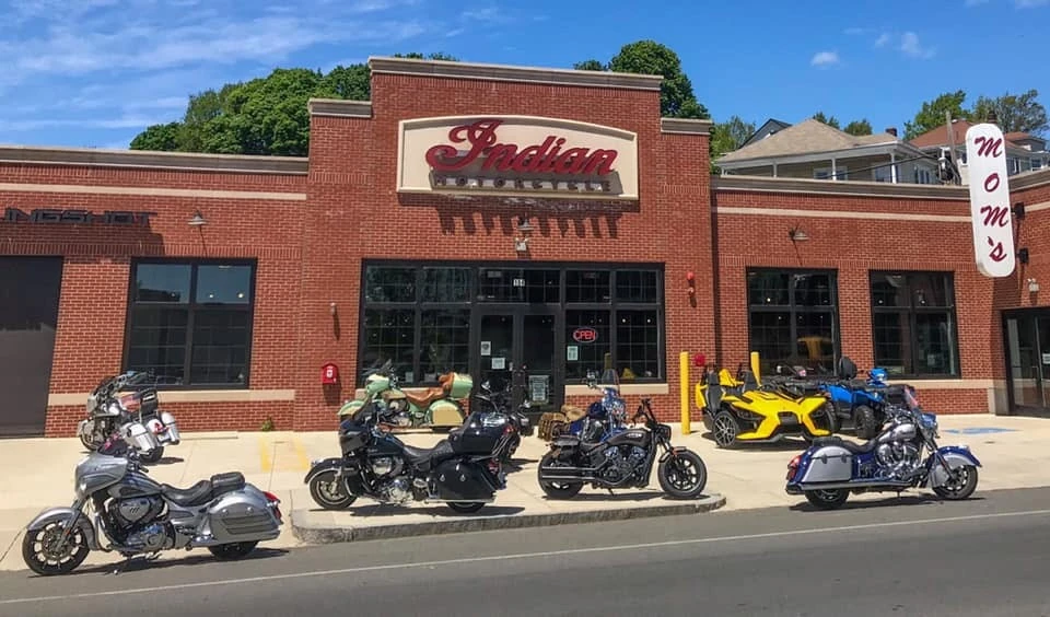 Indian motorcycles parked in front of a brick building.