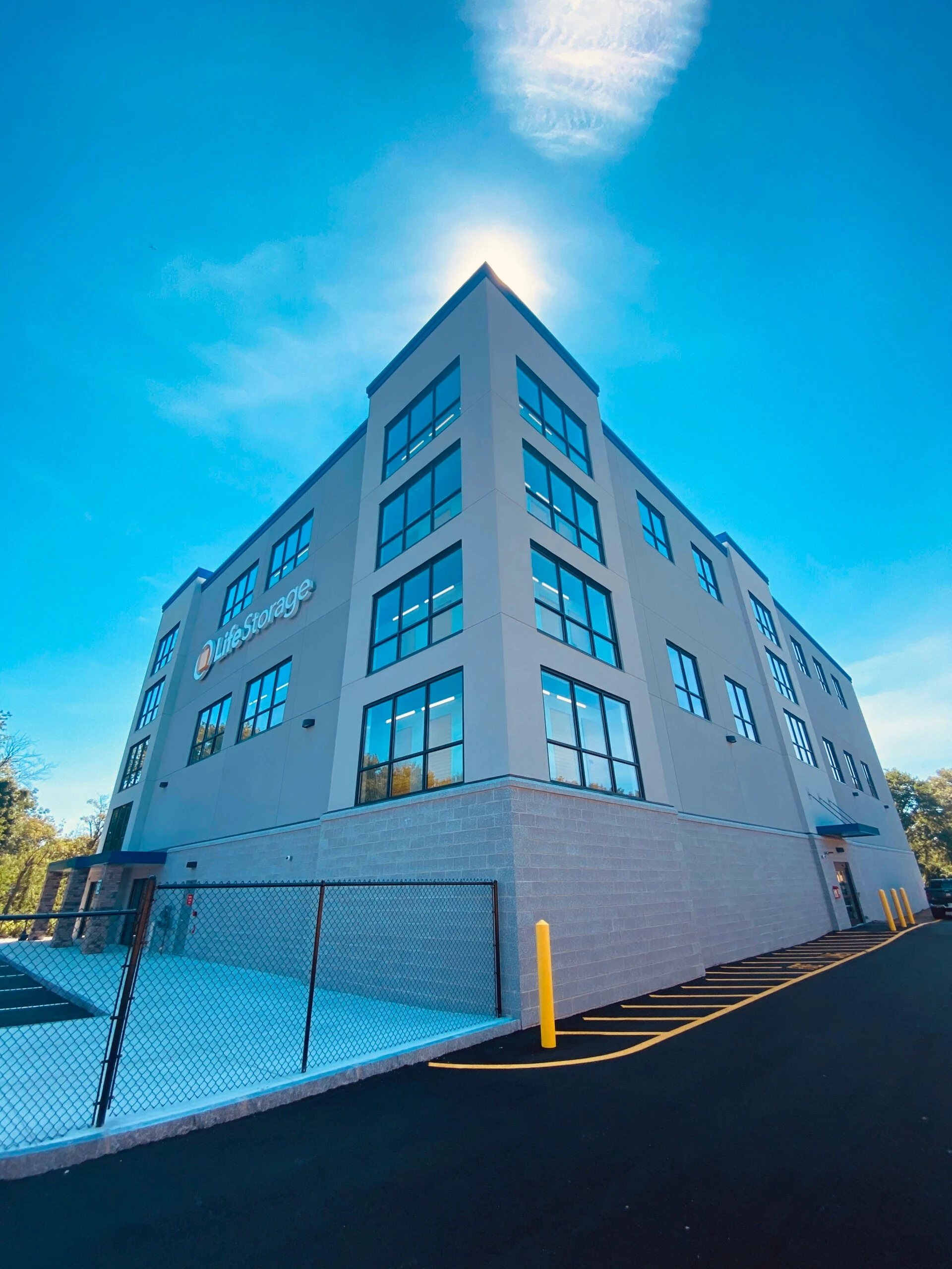 A building with a parking lot and a blue sky.