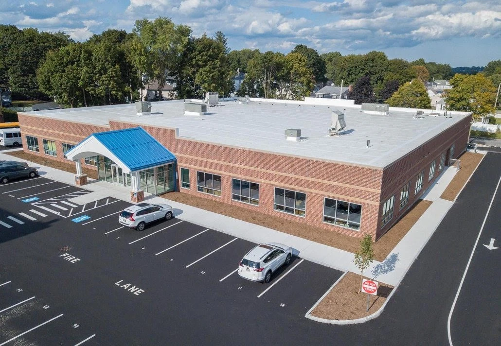 An aerial view of a building with a parking lot.