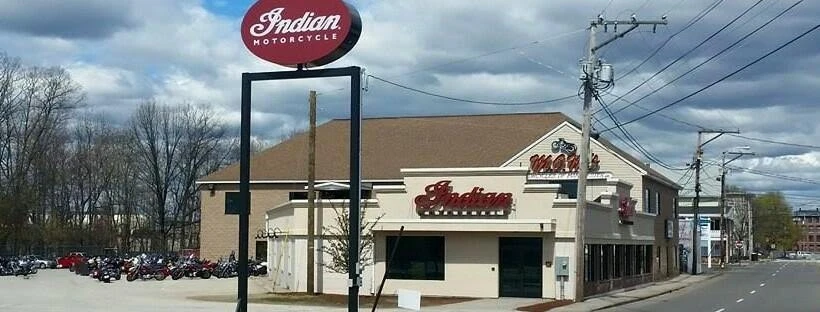 An indian restaurant with motorcycles parked in front of it.