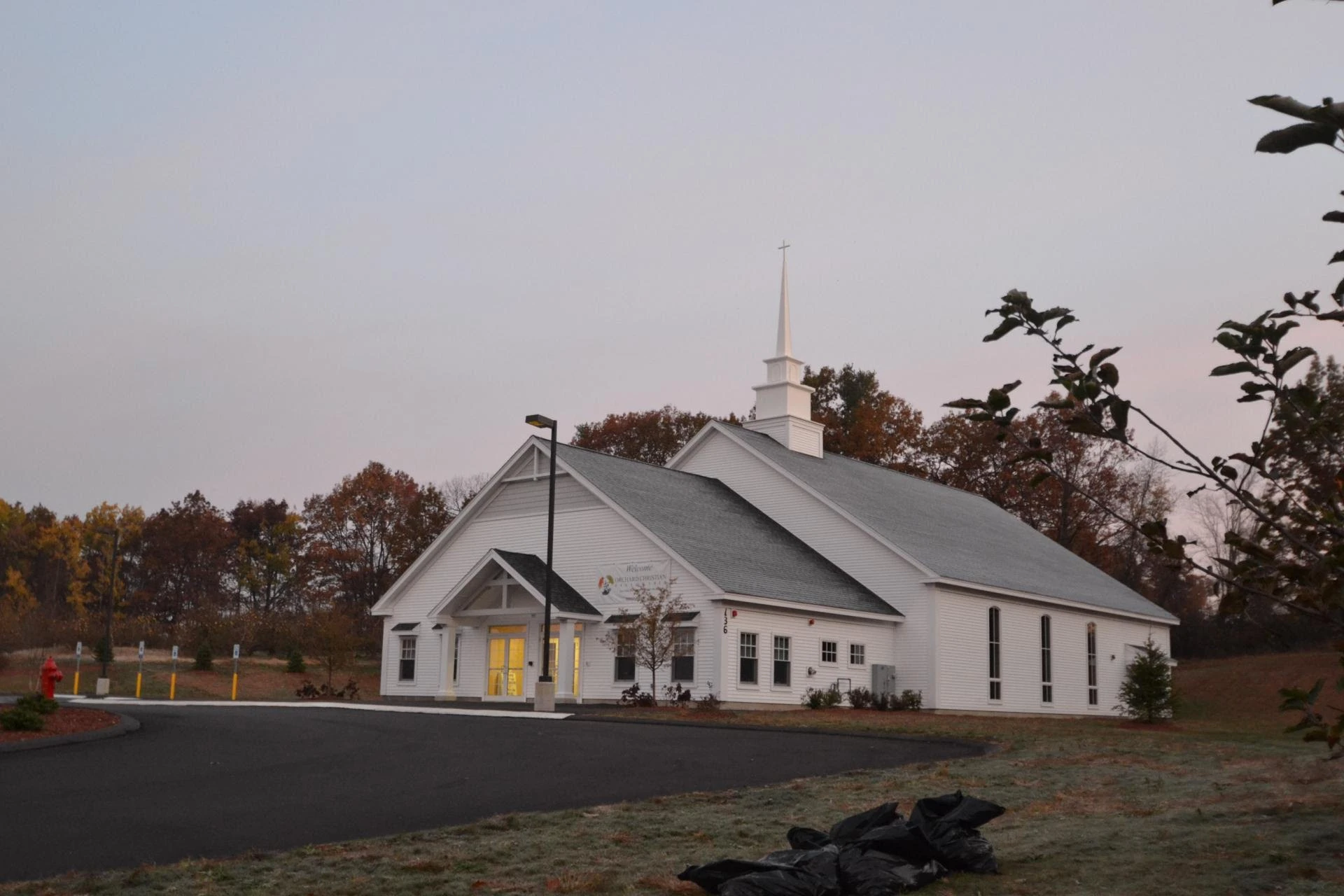 A white church in the middle of a road.